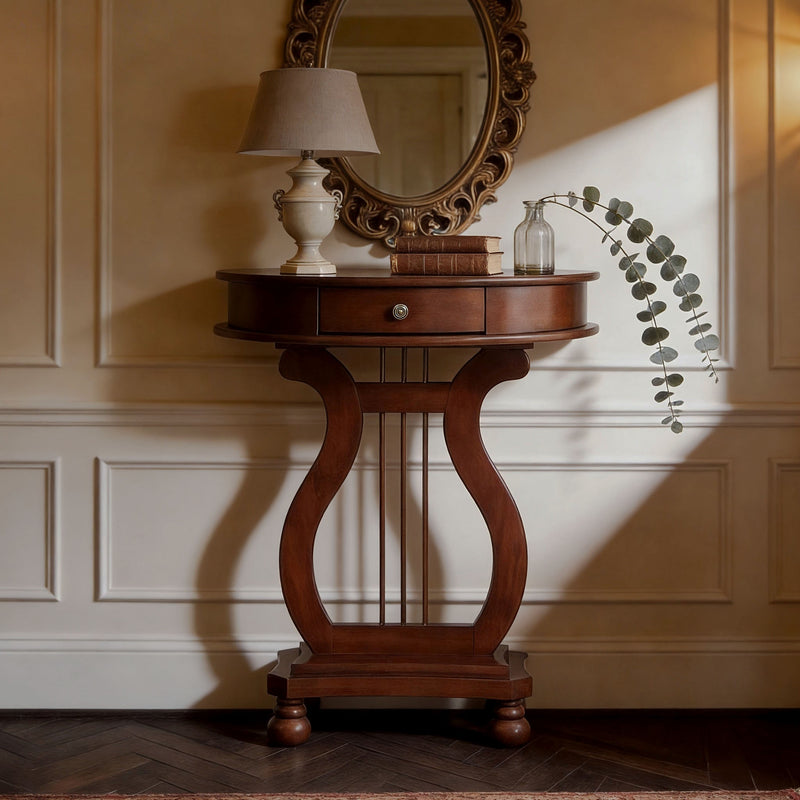 Cherry brown demi-lune console with a harp-shaped base below an ornate mirror.