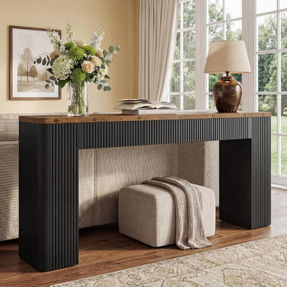 Brown and black fluted console behind a sofa near a bright window.