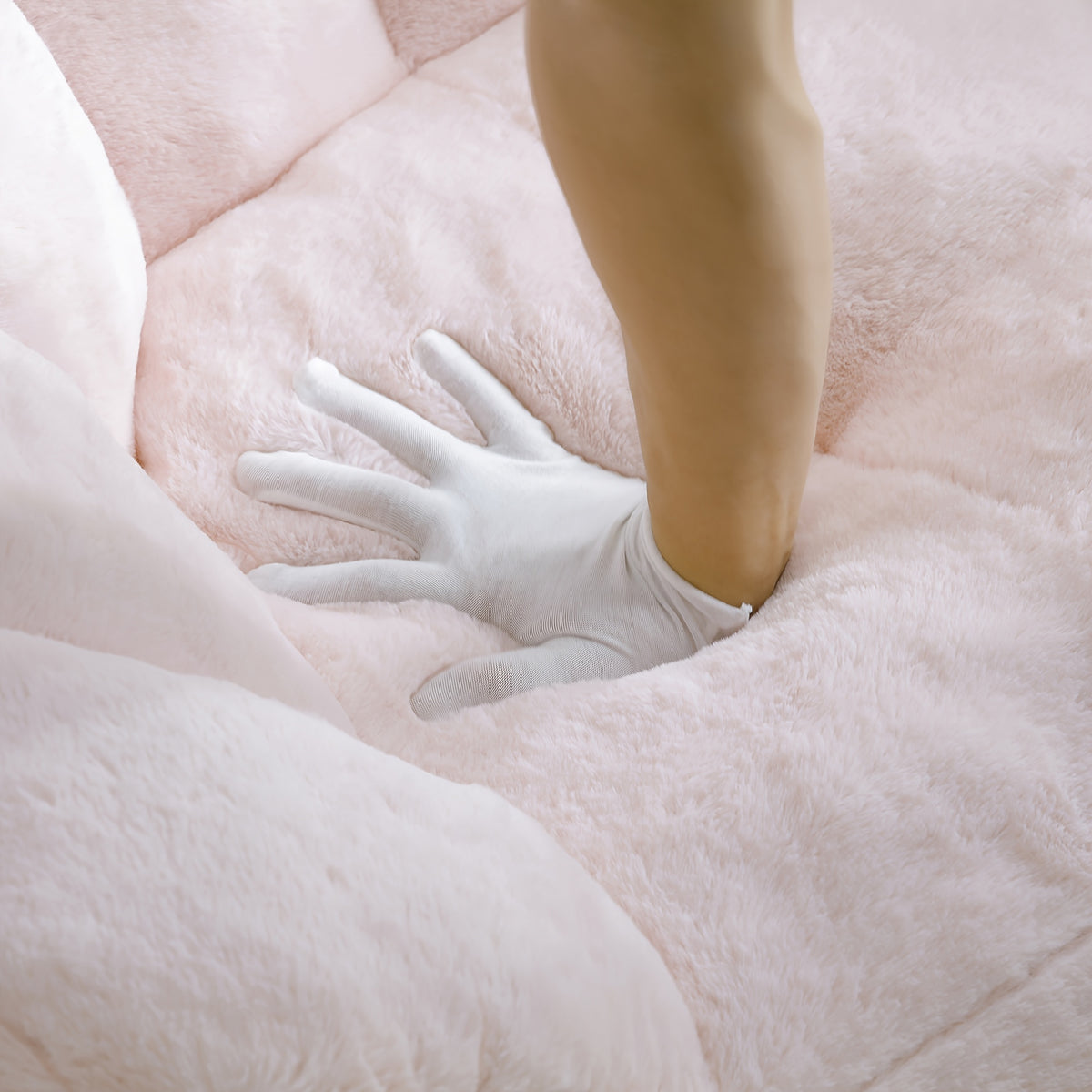 Seashell Faux Fur Lounge Chair with Footrest — seat cushion compression demonstration.