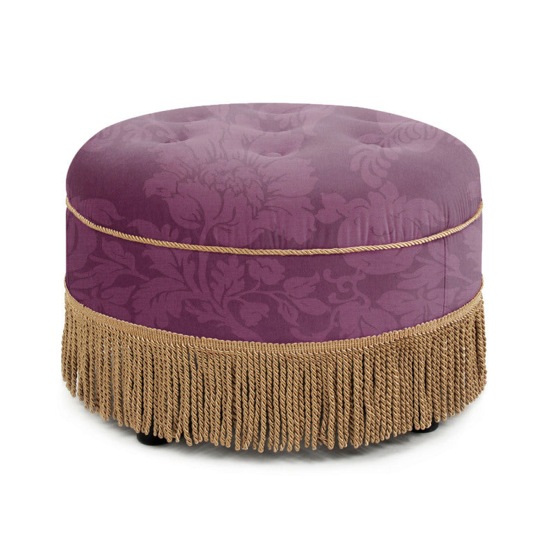 Angled view of the purple floral ottoman and gold fringe