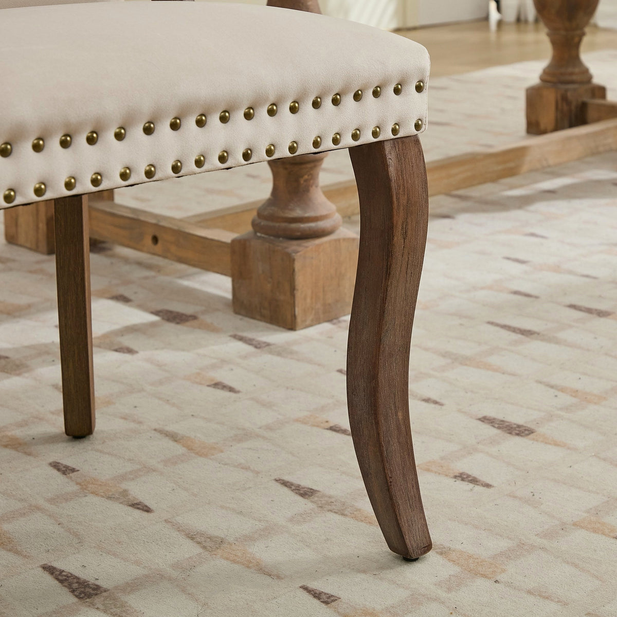Beige velvet dining chair with a tufted back, wood handle, and curved wood legs