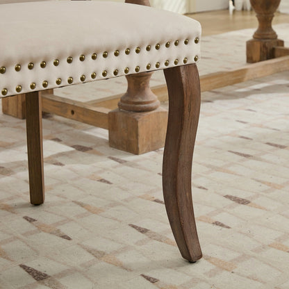 Beige velvet dining chair with a tufted back, wood handle, and curved wood legs