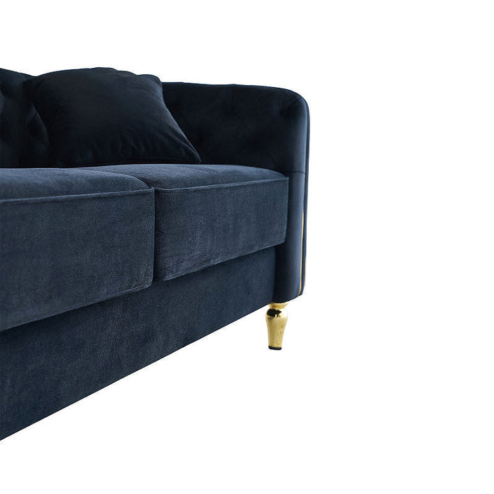 Close-up of black sofa seat cushions, accent pillow and gold-tone leg