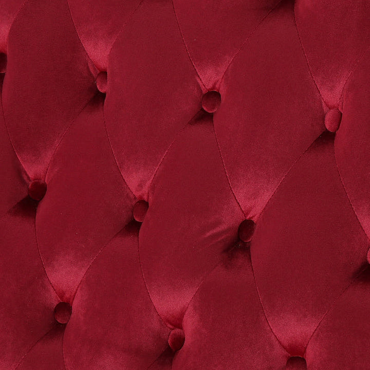 Close-up of the wine red velvet upholstery and diamond button tufting.