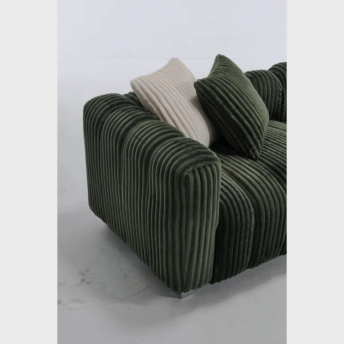 Close-up of the green sofa's ribbed arm and back cushions