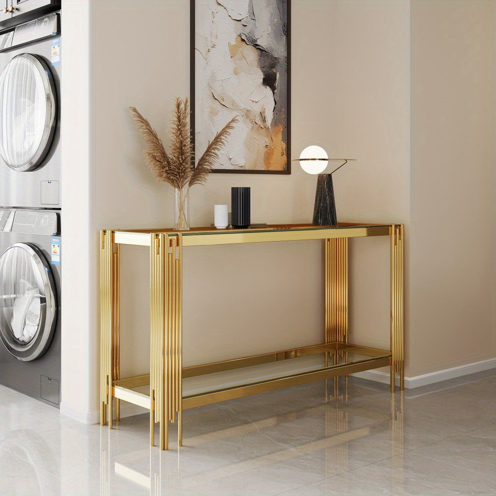 Angled room view of the gold console showing glass display surfaces and slim rod legs
