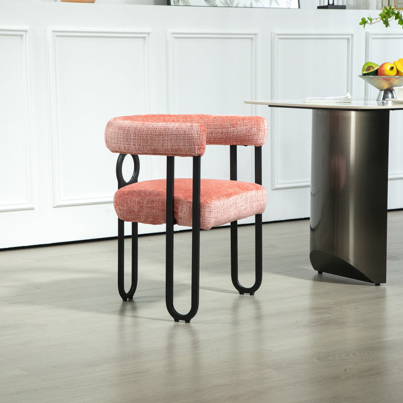 Rear angle of the pink chair's open back and circular metal detail