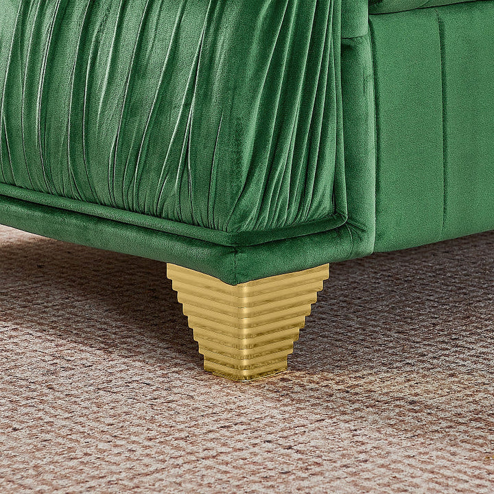 Close-up of green velvet upholstery and stepped gold-tone loveseat leg