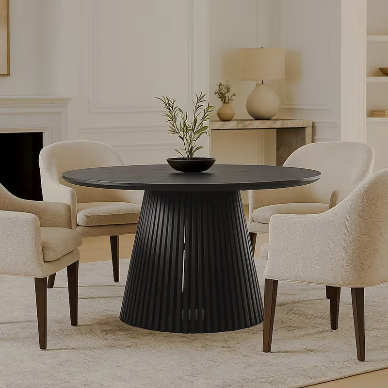 Round black dining table and slatted pedestal in a neutral seating area