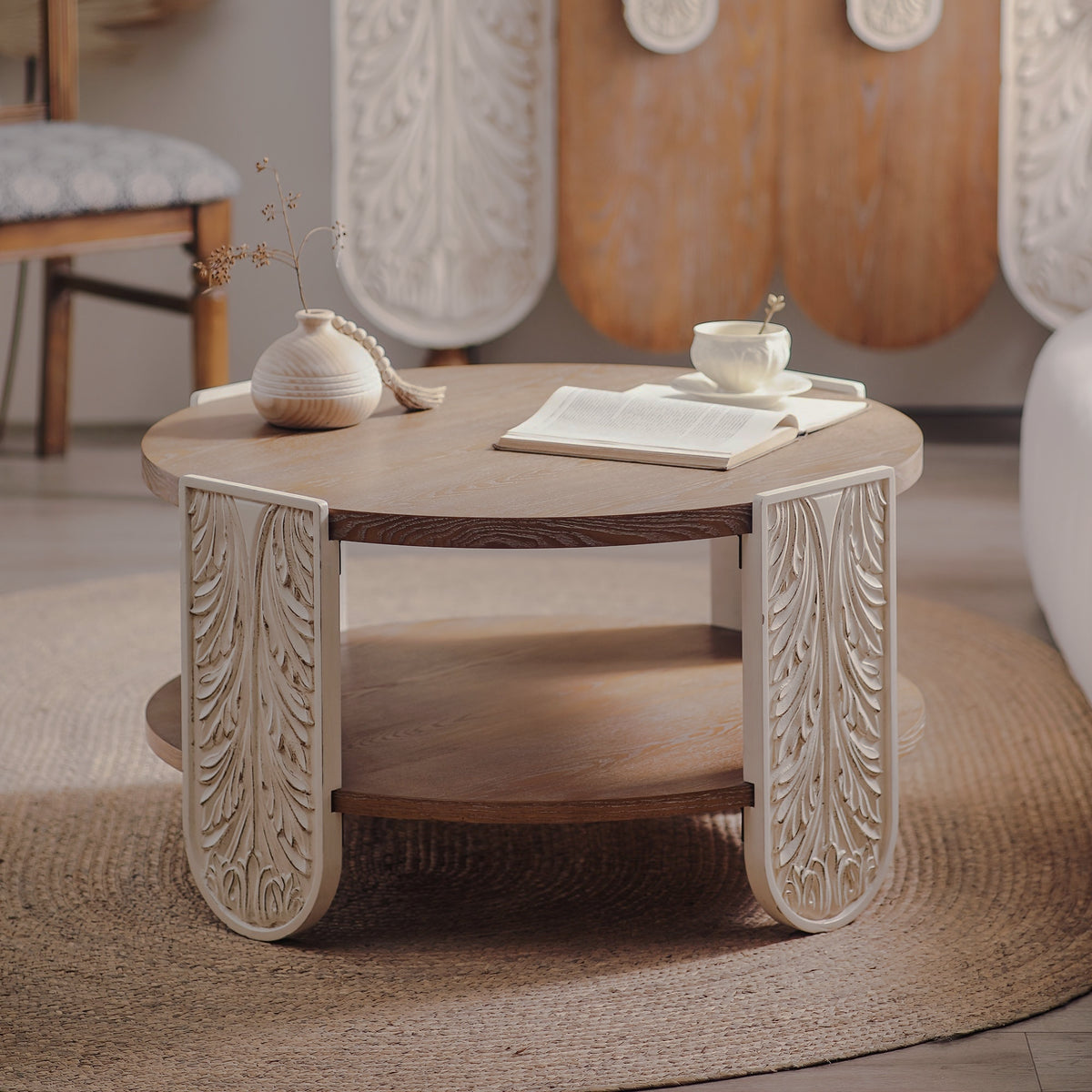 Round brown coffee table with cream leaf-carved legs and lower shelf