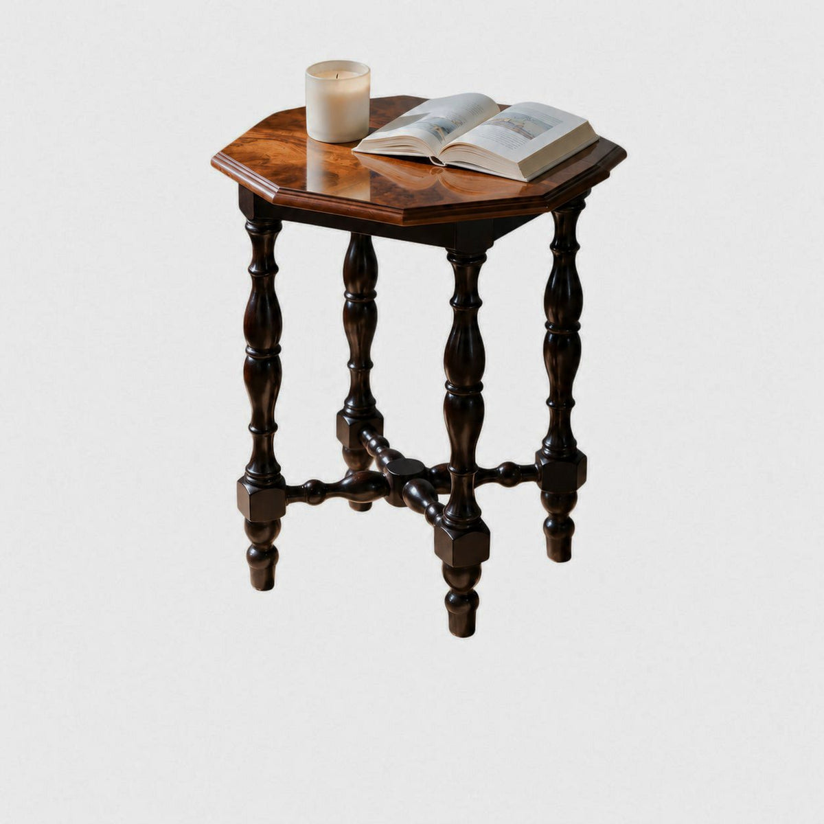 Octagonal walnut burl wood side table with turned legs, candle and open book — clean studio view
