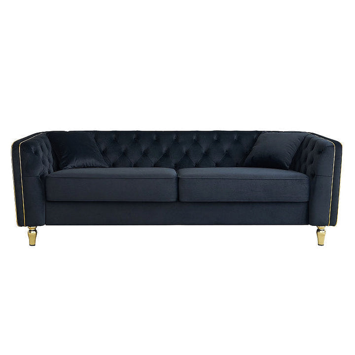 Black tufted sofa with gold-tone piping, straight-on front view