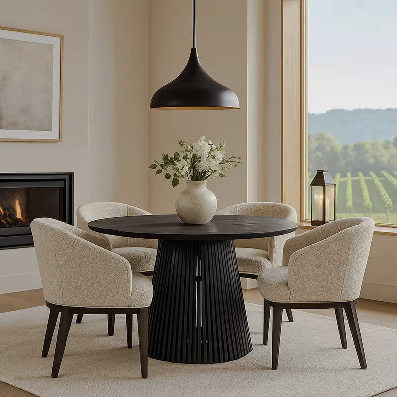 Round black slatted-base dining table styled with flowers beneath a pendant light