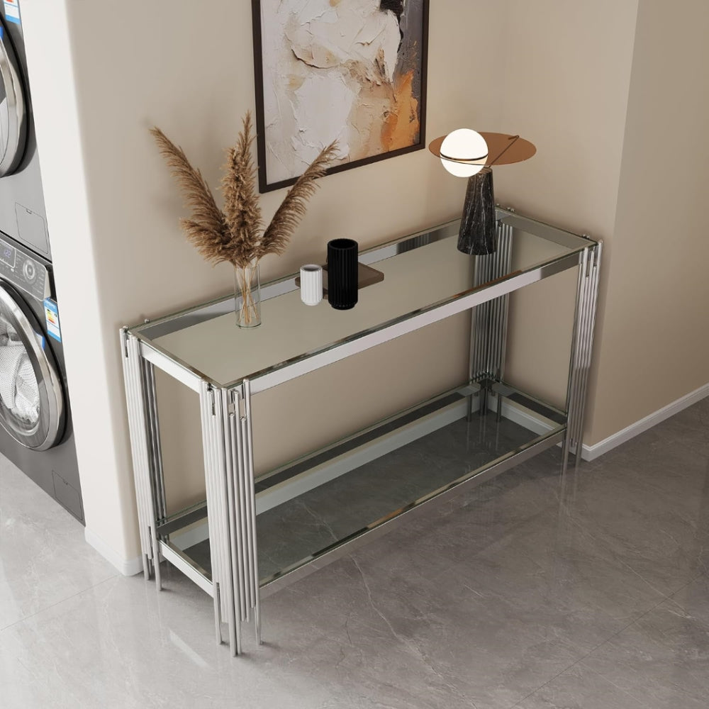 Clear glass and silver frame console styled in an entryway from an elevated angle.