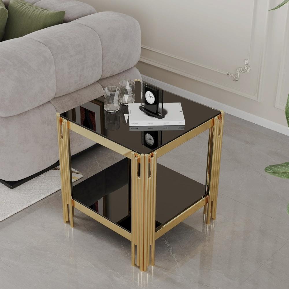 Square two-tier end table with black reflective shelves and a gold-tone frame beside a gray sofa