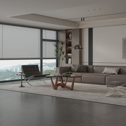Dark glass coffee table with a curved sculptural brown base in a gray living room