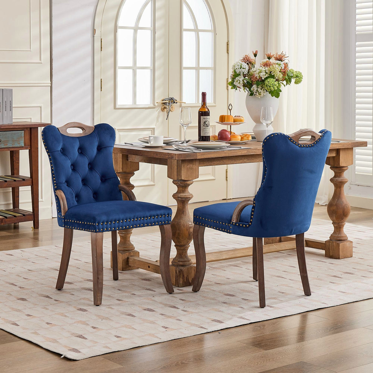 Blue velvet dining chair with a tufted back, wood handle, and curved wood legs