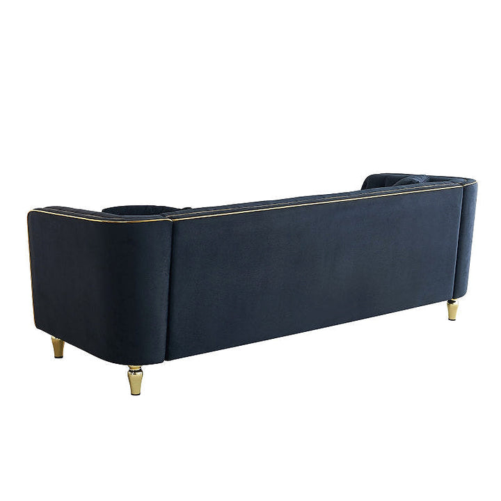 Black upholstered sofa with gold-tone piping, angled rear view