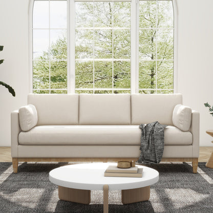 Knox French Beige Velvet Sofa — front sofa view beside a window.