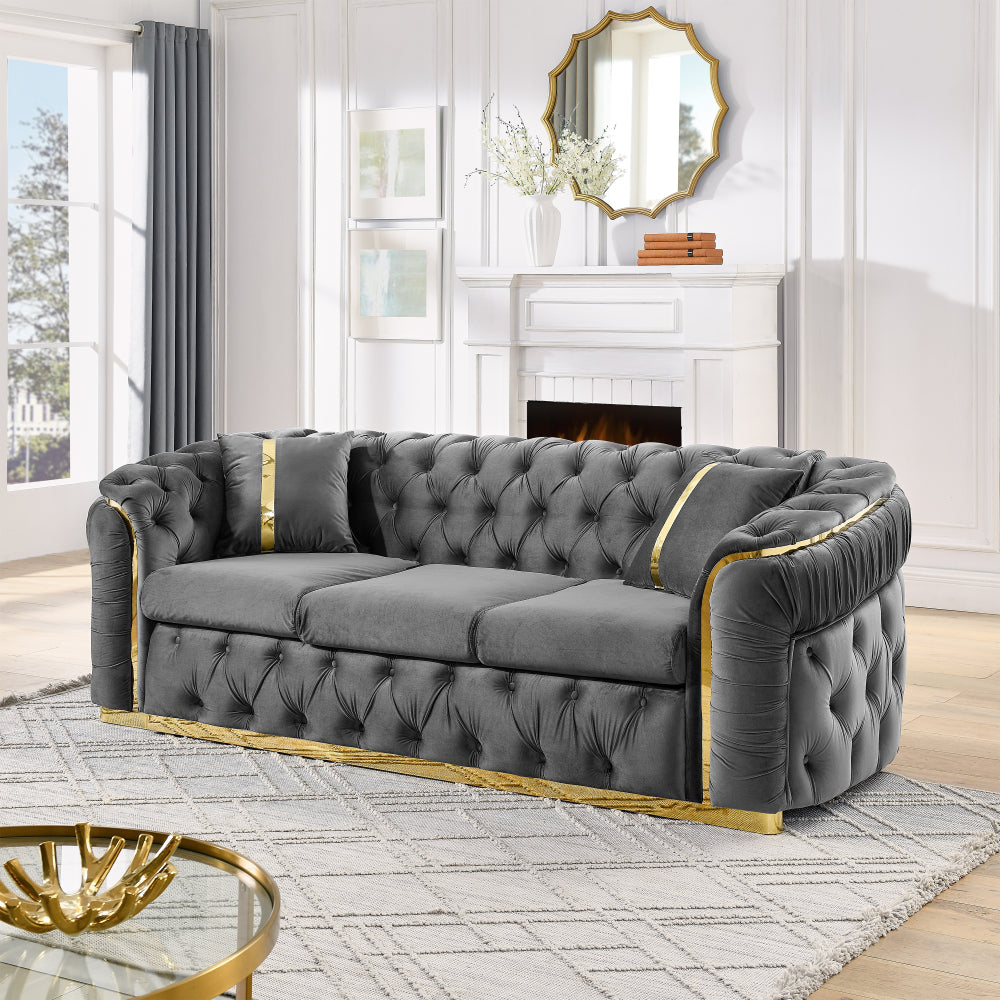Velvet Chesterfield Sofa with Gold-Tone Trim — grey sofa angled room view.