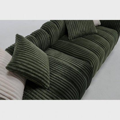 Angled close-up of the green sofa's arm, seat and back cushions