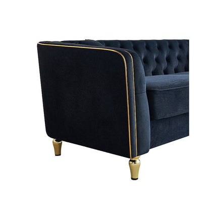 Close-up of the black sofa curved arm, gold-tone piping and leg
