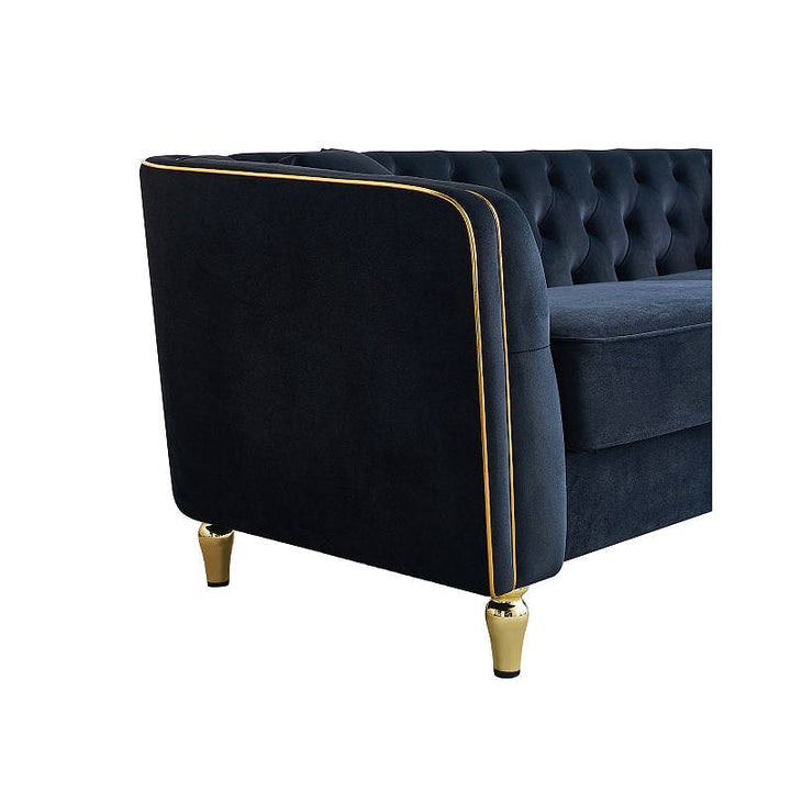 Close-up of the black sofa curved arm, gold-tone piping and leg