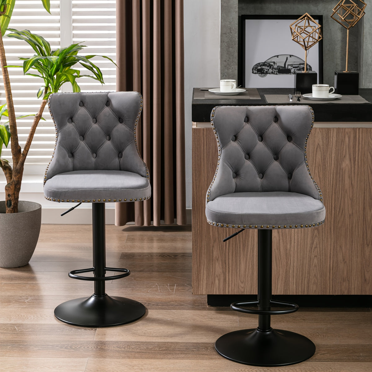 Two gray velvet swivel bar stools with circular footrests