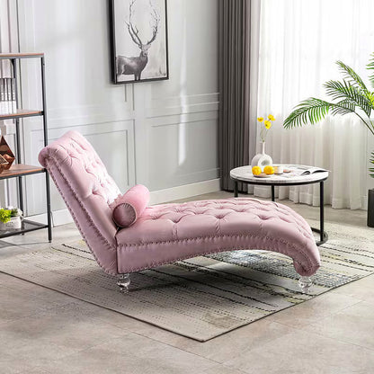 Pink velvet tufted chaise lounge with clear acrylic feet and a bolster pillow