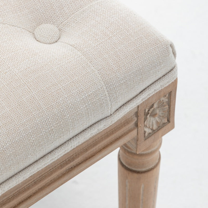 Detail of beige woven upholstery, piping and a covered button