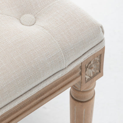 Detail of beige woven upholstery, piping and a covered button