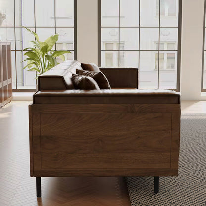 End view of the brown sofa showing its wood side panel and dark leg