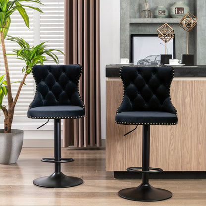 Two black tufted swivel stools at a bar counter