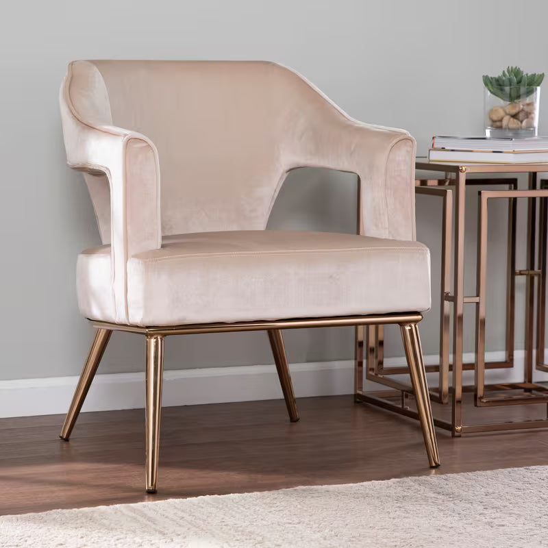 Eldermain Blush Velvet Accent Chair — pale blush chair with gold-colored legs in a room