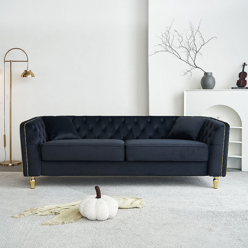 Lucien black tufted sofa with gold-tone piping in a living room