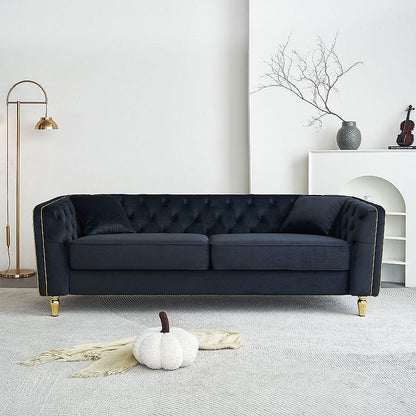 Lucien black tufted sofa with gold-tone piping in a living room
