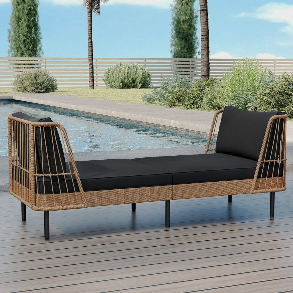 Wicker patio daybed with black seat and back cushions beside a pool