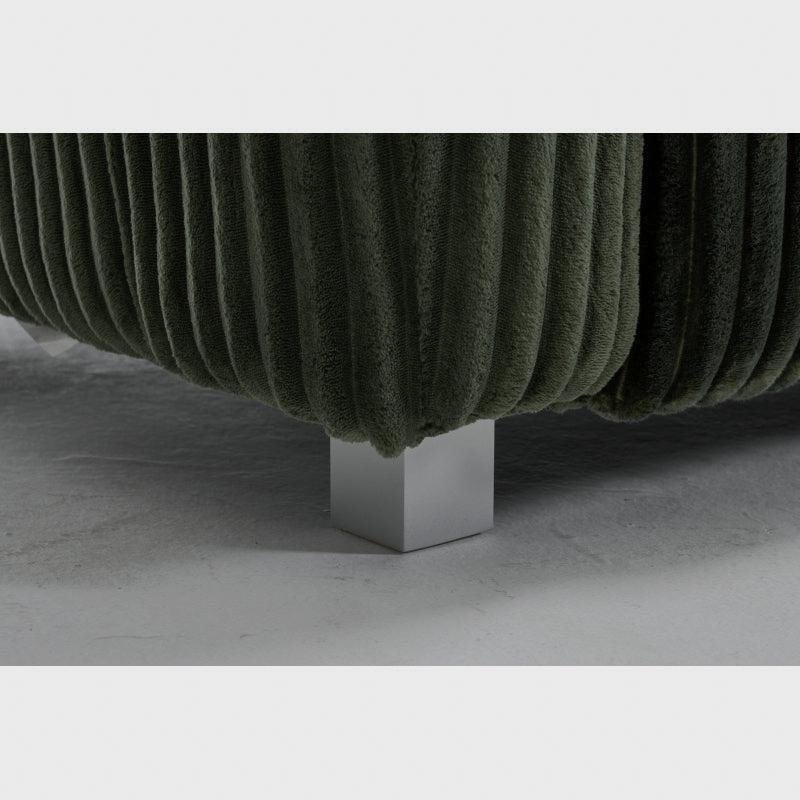 Close-up of the green ribbed sofa's silver-tone foot