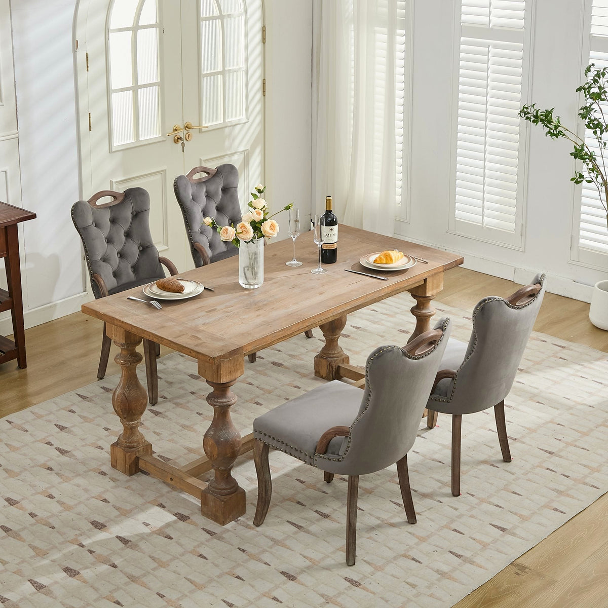 Gray velvet dining chair with a tufted back, wood handle, and curved wood legs