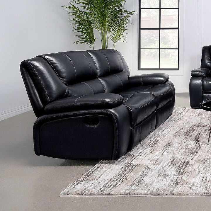 Angled view of the Elodie black reclining loveseat in a living room