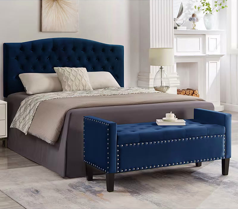 Navy tufted storage bench at the foot of a bed