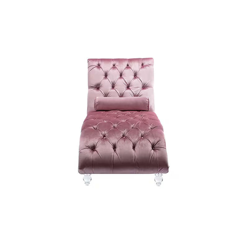 Pink velvet tufted chaise lounge with clear acrylic feet and a bolster pillow