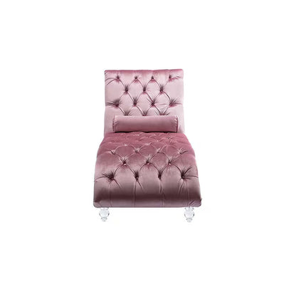 Pink velvet tufted chaise lounge with clear acrylic feet and a bolster pillow