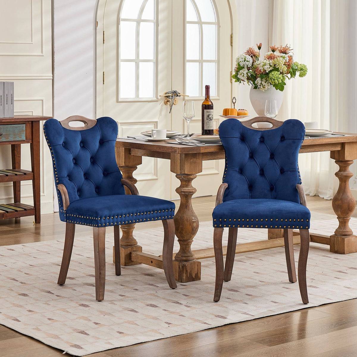 Blue velvet dining chair with a tufted back, wood handle, and curved wood legs