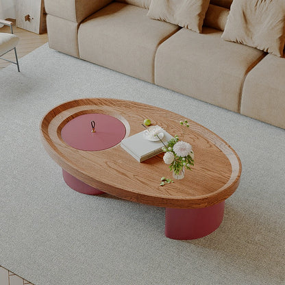 Angled overhead view of the oval coffee table and circular red storage lid