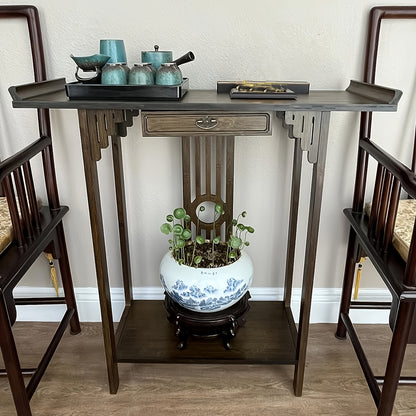 Front view of the brown bamboo console displayed between two chairs.