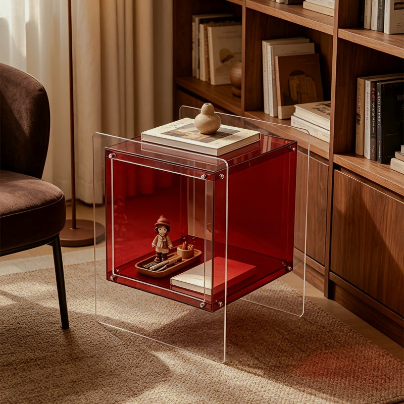 Red and clear acrylic side table with books on top beside a bookcase