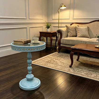 Light blue glass-top side table in a traditional seating area.