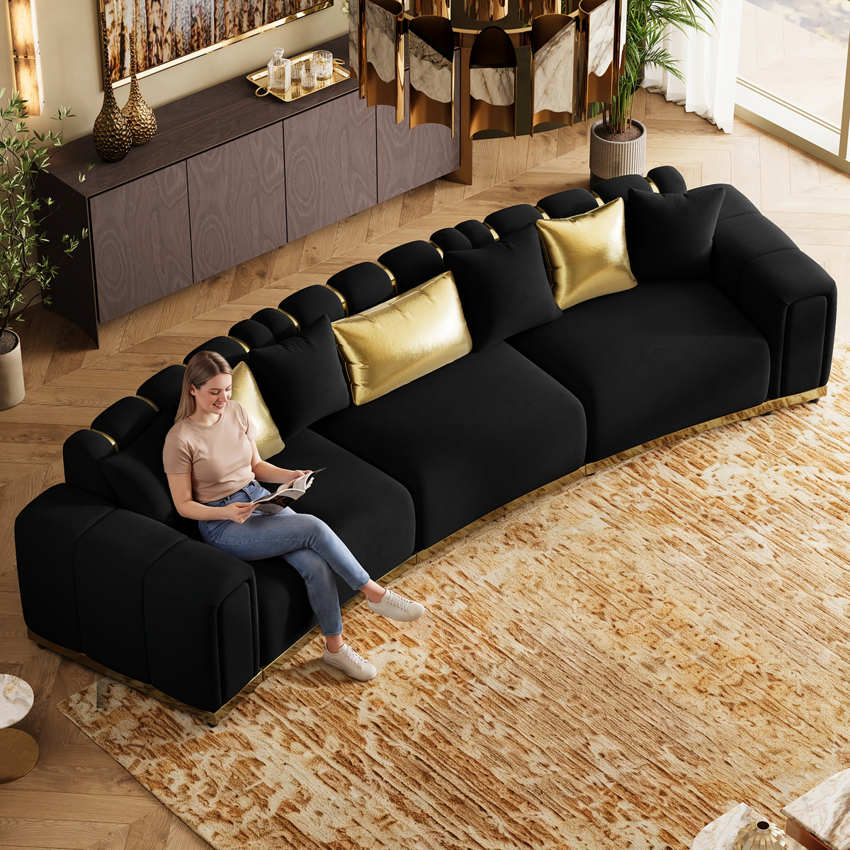 Curved Velvet Sofa with Metal Trim — overhead sofa view shown with seated person.