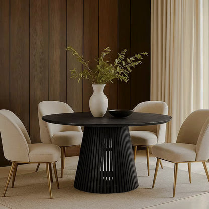 Round black dining table with cream chairs beside a dark paneled wall